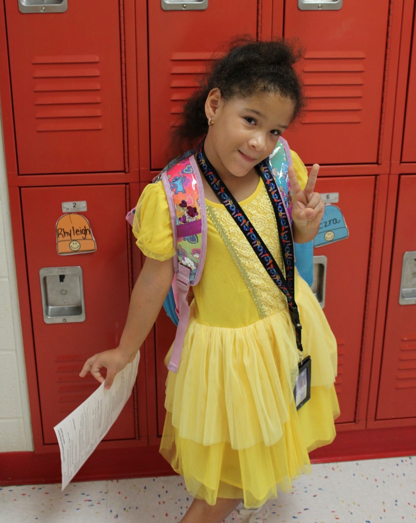 Student in neon dress princess poses by lockers