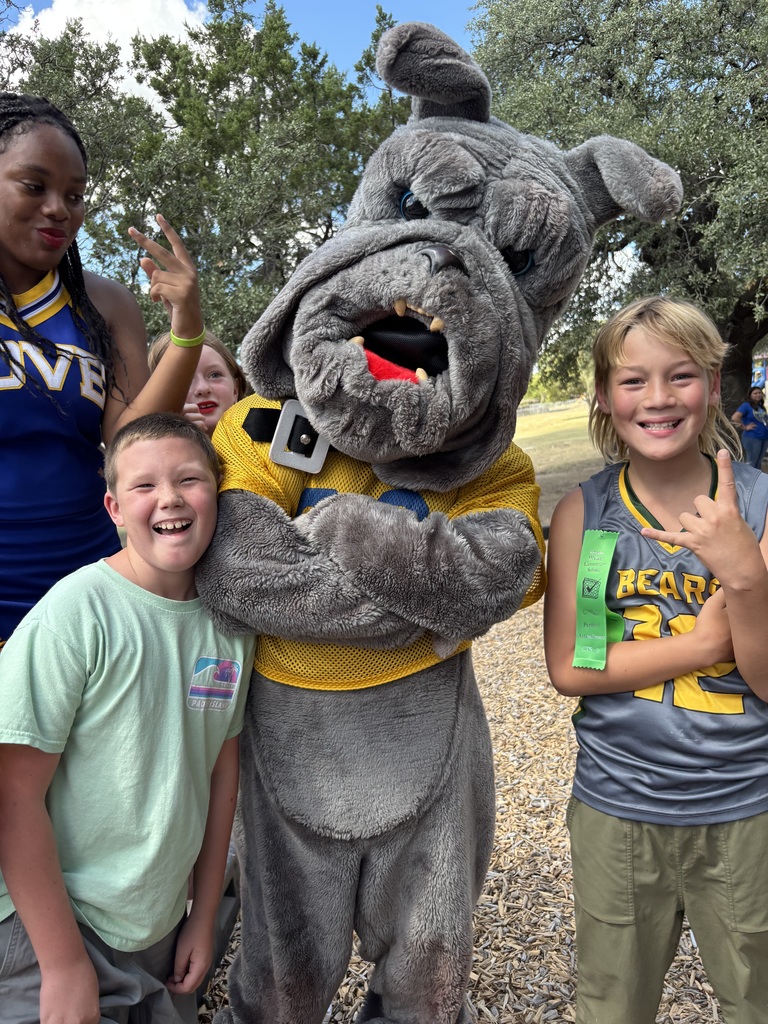 Cheerleaders and mascot posing with elementary students