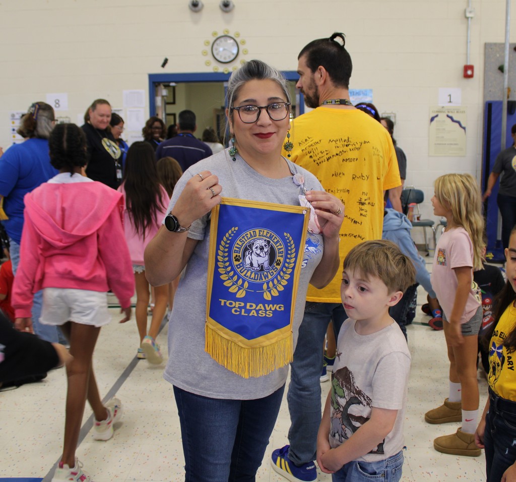 Ms. Peck poses with Top Dawg Banner