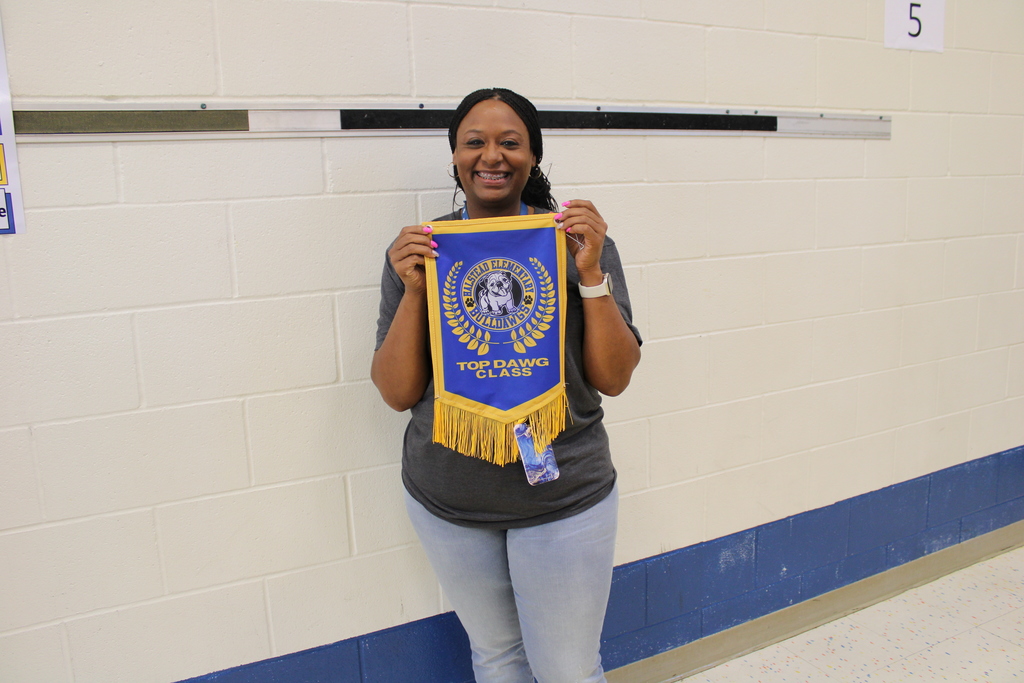 Ms. Burnell poses with Top Dawg Banner