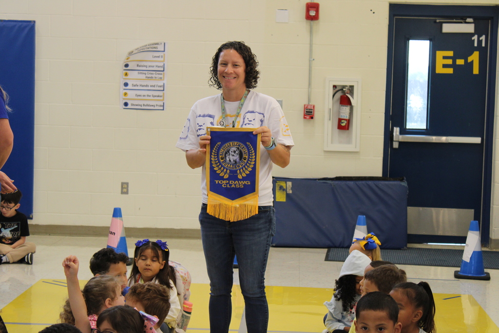 Ms. Battenfield poses with Top Dawg Banner