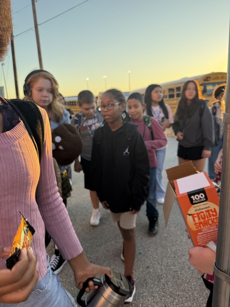 Picture of students greeting arriving to campus students with a HELLO and snacks