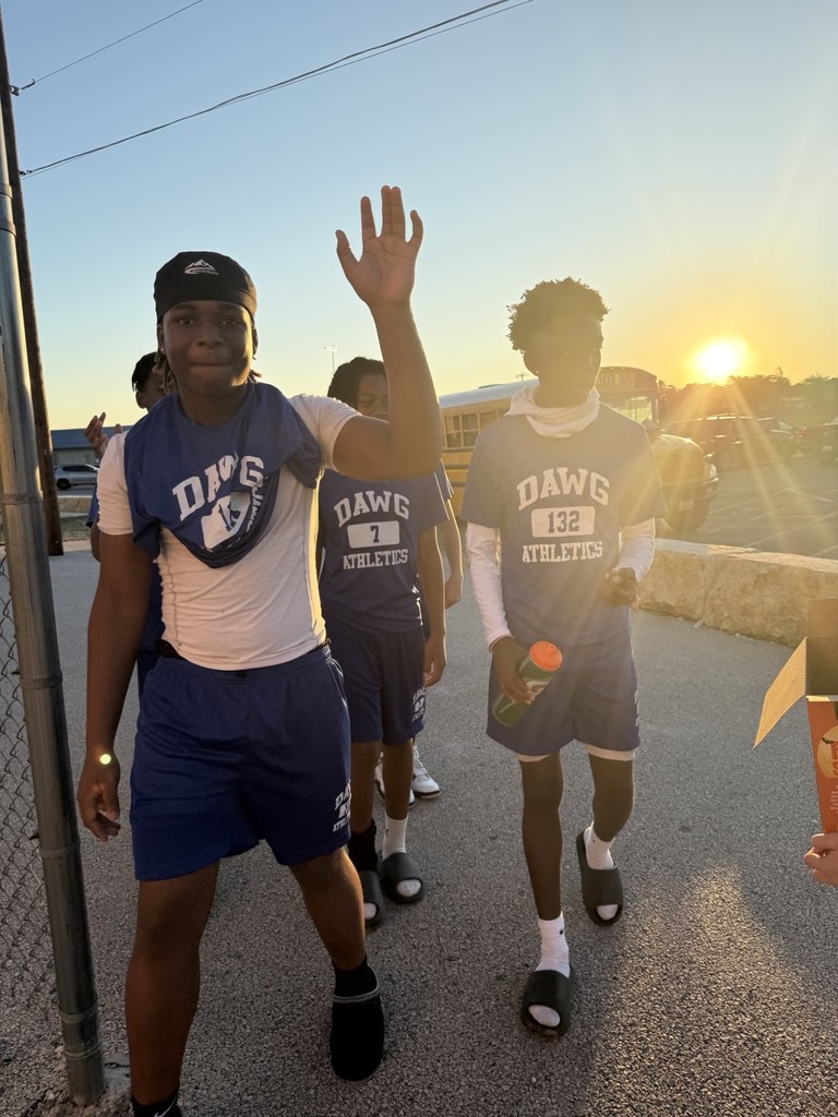 Picture of students greeting arriving to campus students with a HELLO and snacks