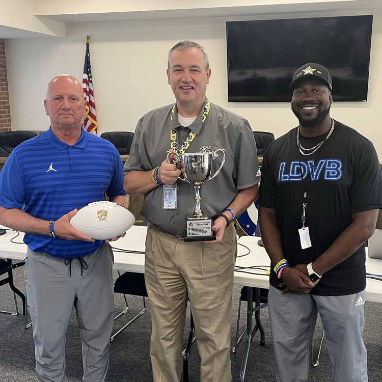 Three men posing with a trophy