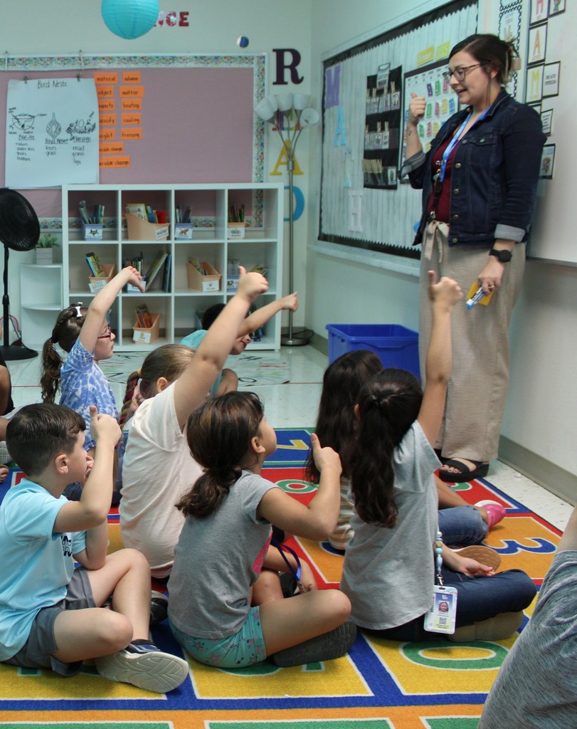Ms. Klein and students give answer thumbs up