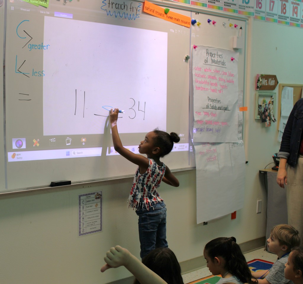student writes answer on whiteboard