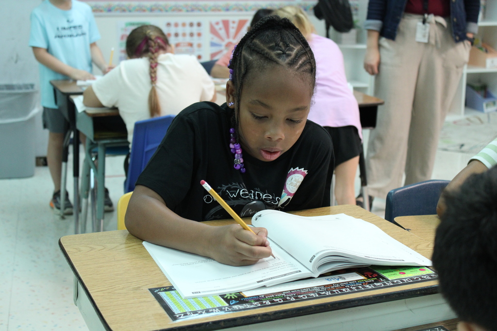student writes in workbook