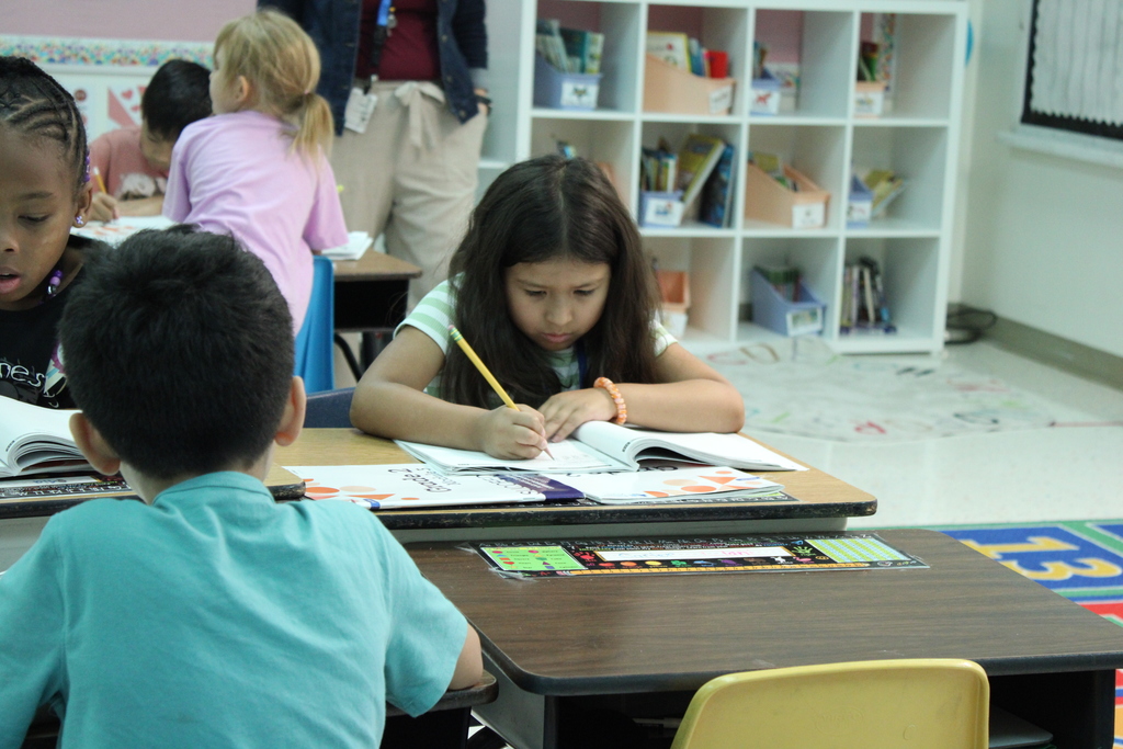 student writes in workbook