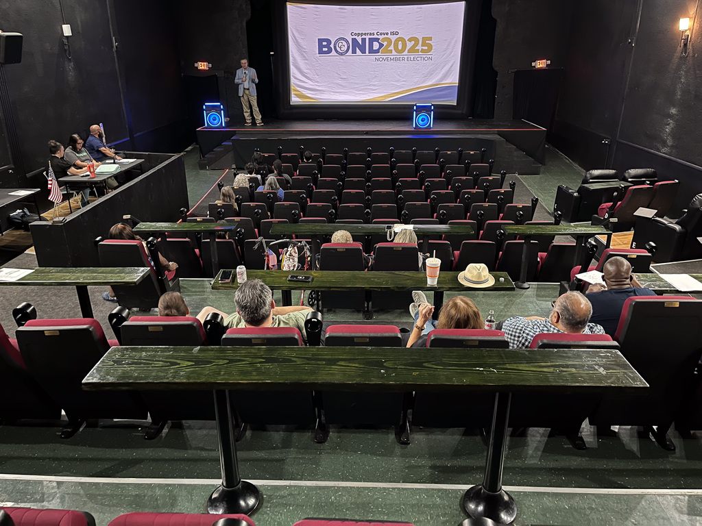 A theater with people listening to a presenter