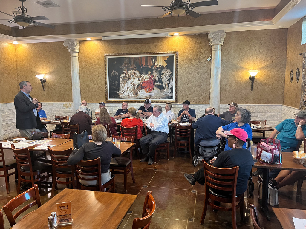 A man speaking to a group at a restaurant