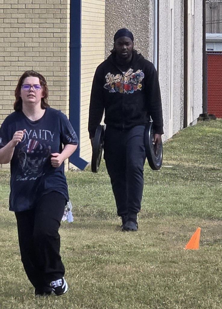 Picture of students participating in weight carry fitness challenge.