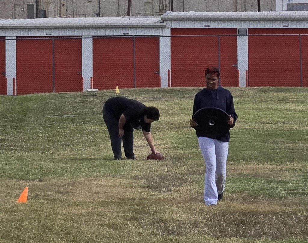 Picture of students participating in weight carry fitness challenge.