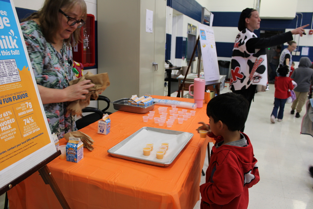 Student at table tasting orange milk
