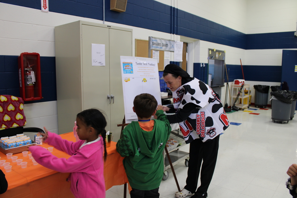 staff member helping student write vote on poster
