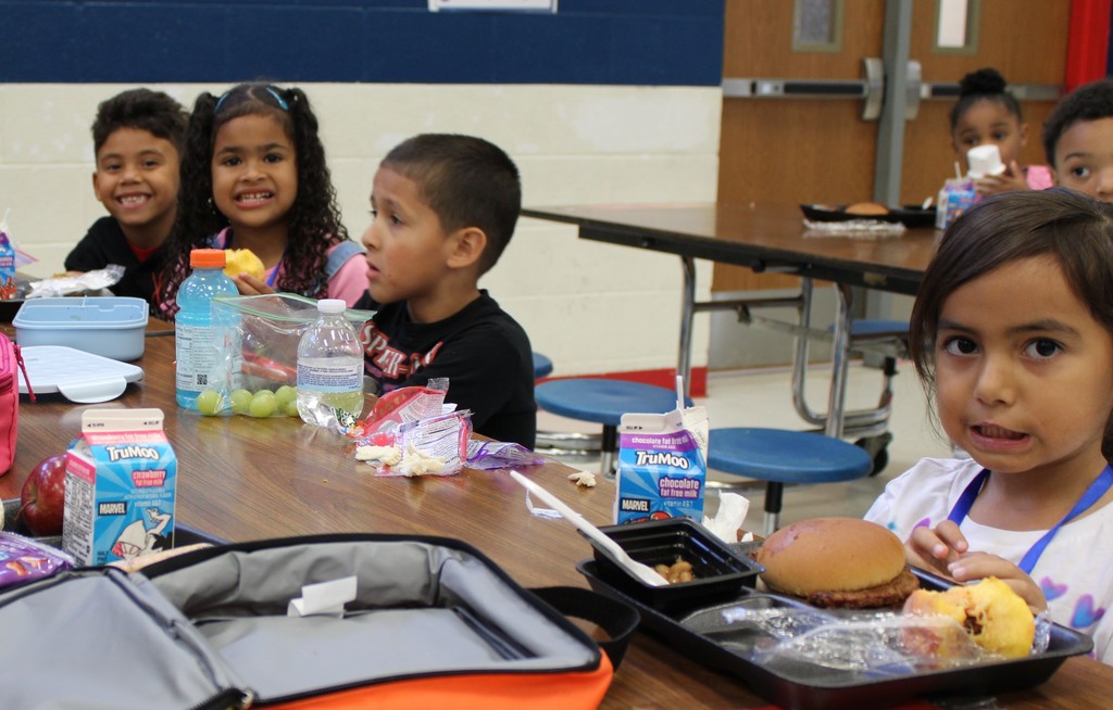 Students smile while eating lunch