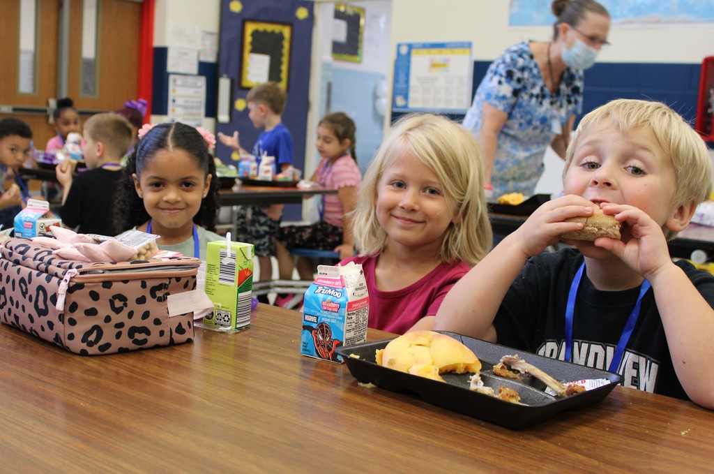 Students smile while eating lunch