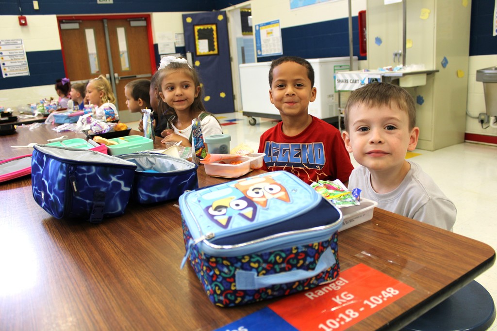 Students smile while eating lunch