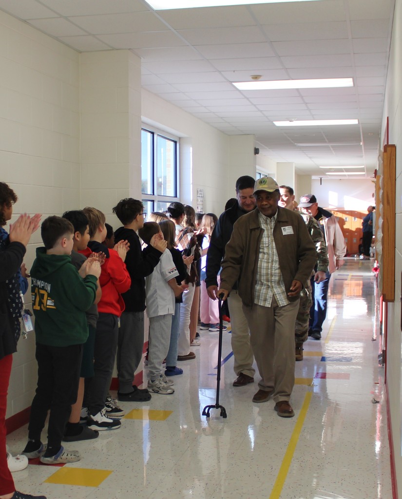 Veterans walk down hallway in parade