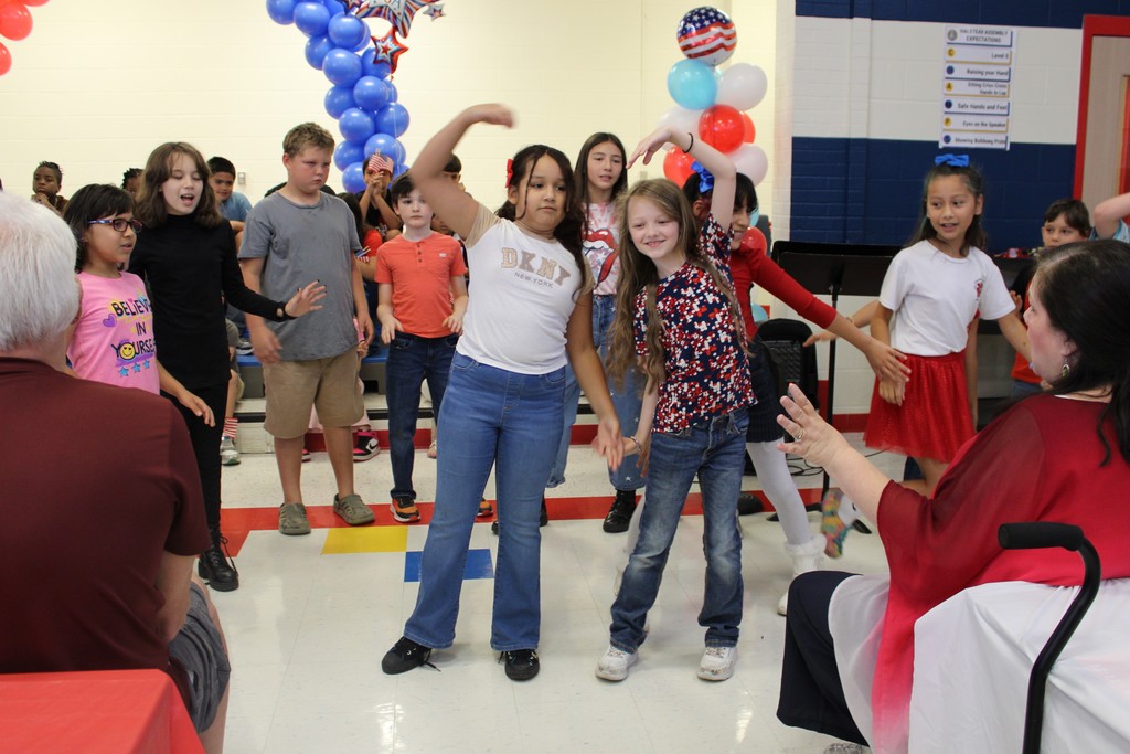 Students perform dance and create hand heart