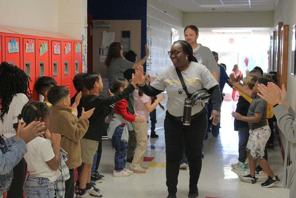 Ms. T high fives student during Veterans parade