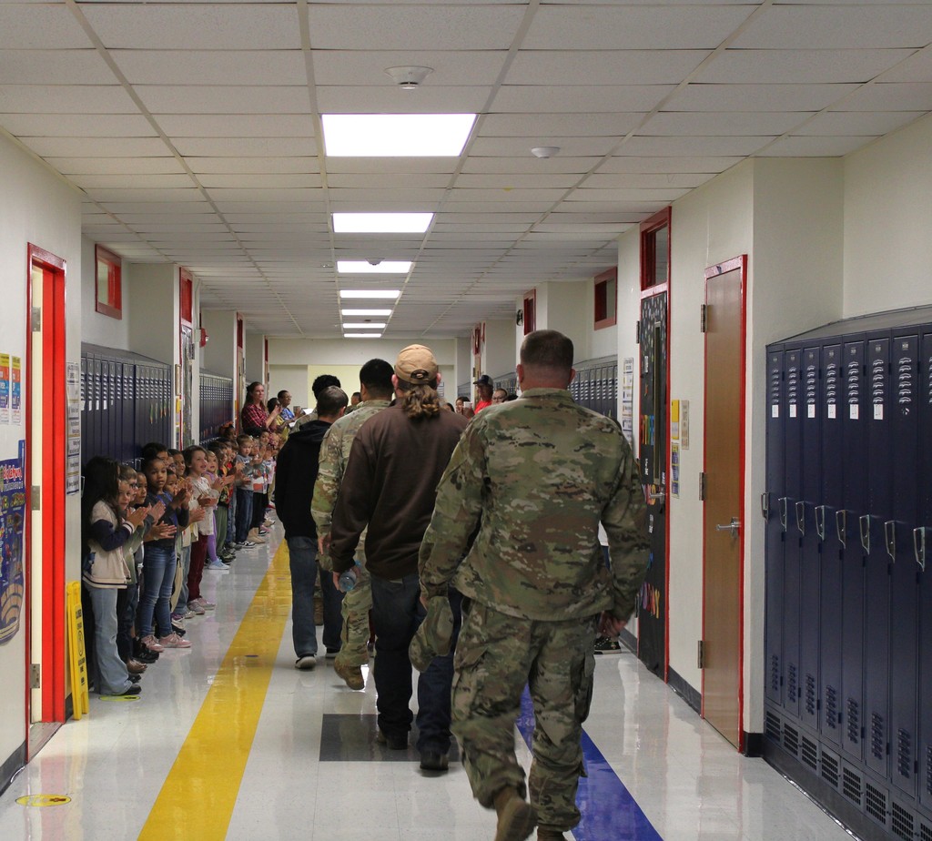 Veterans walk down hallway in parade