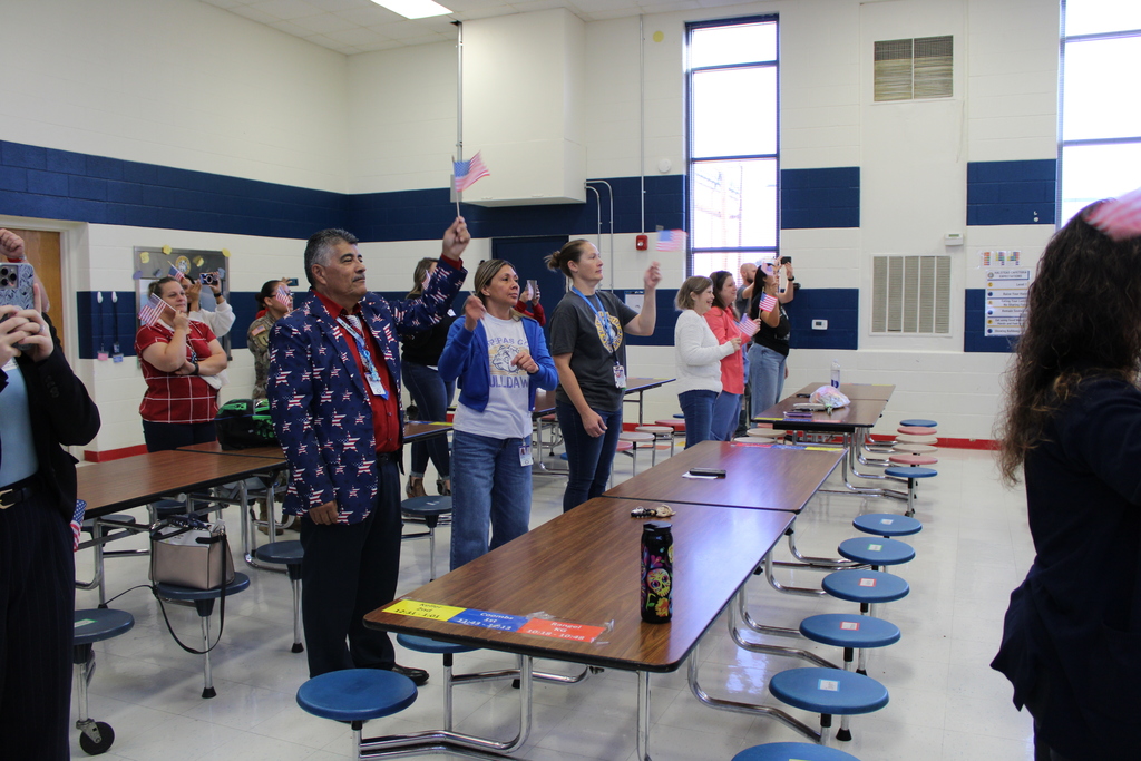 Teachers and parents wave flags in cafeteria