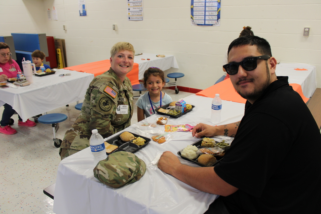 Student pose with parents for Thanksgiving feast