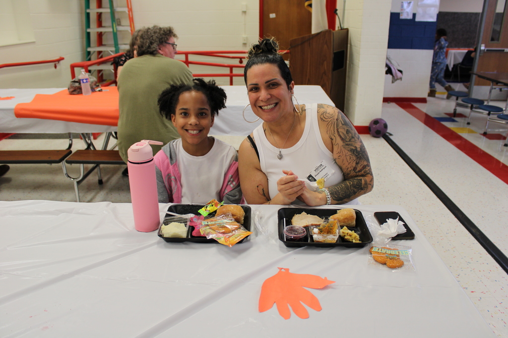 Student pose with parents for Thanksgiving feast