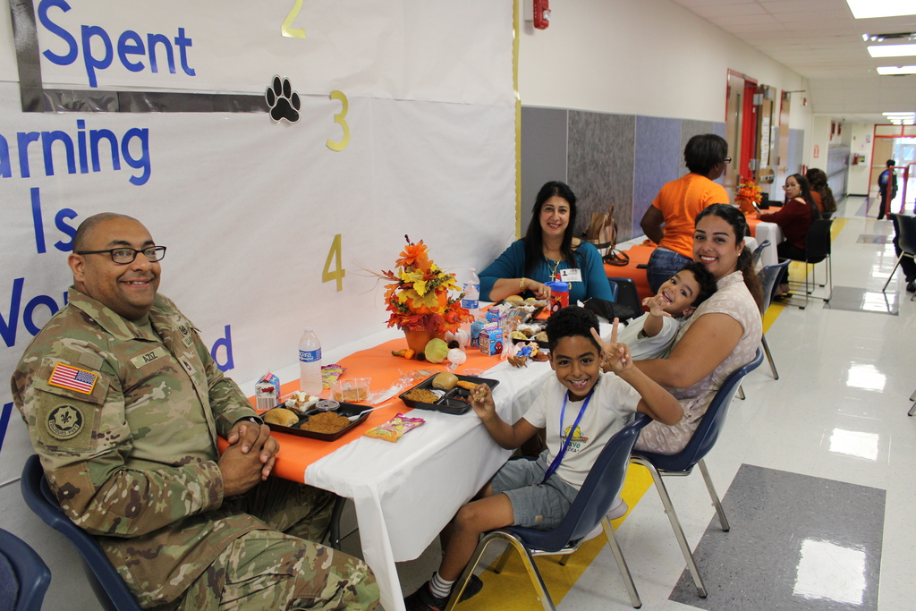 Student pose with parents for Thanksgiving feast