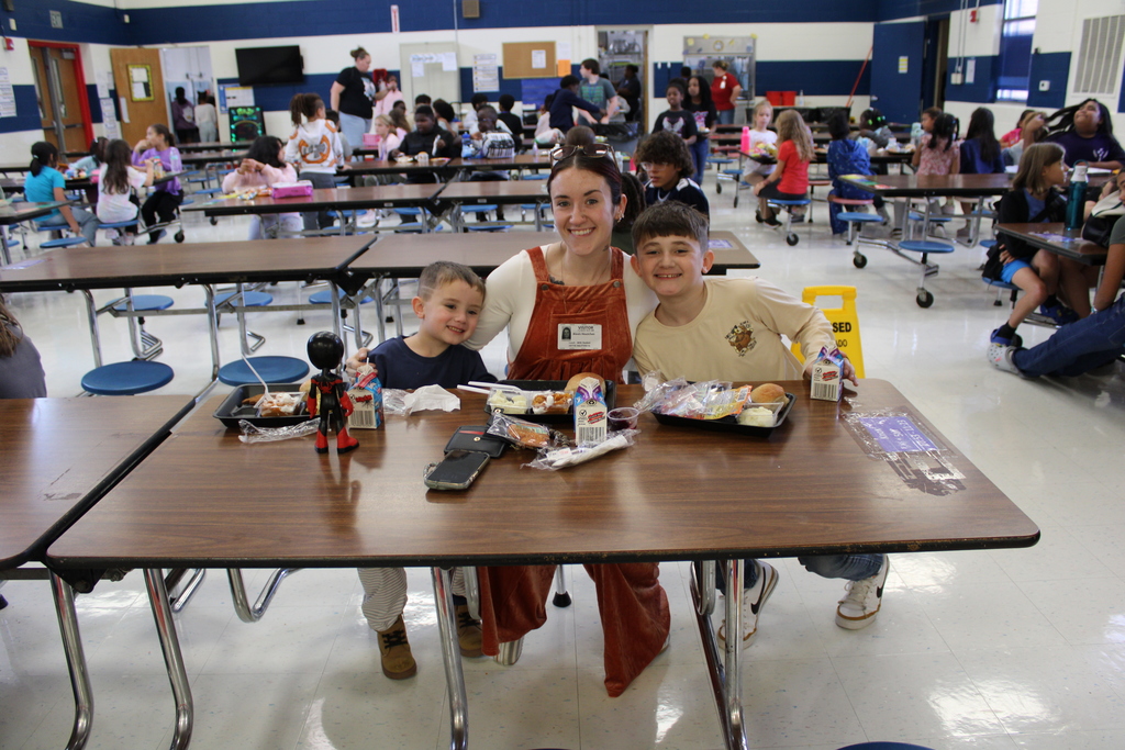 Student pose with parents for Thanksgiving feast