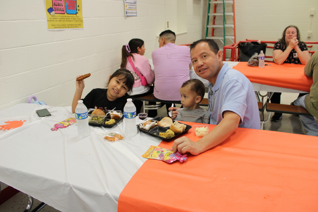 Student pose with parents for Thanksgiving feast
