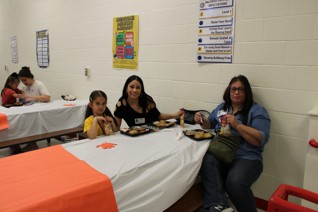 Student pose with parents for Thanksgiving feast