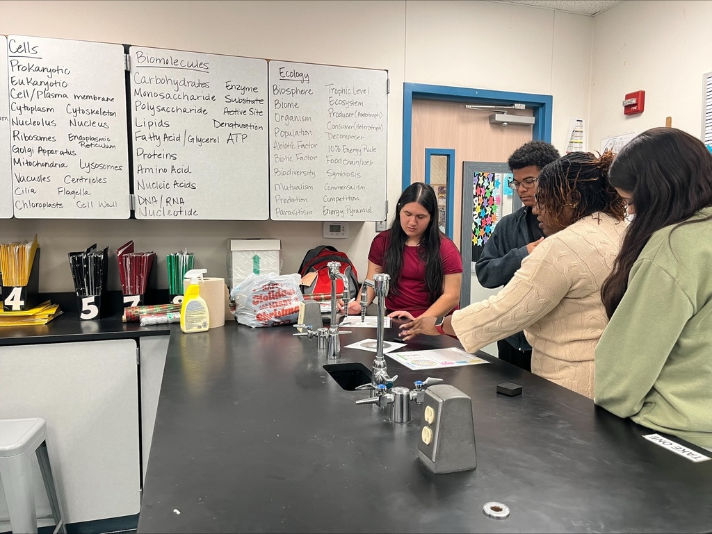 Students next to a teacher working through an activity