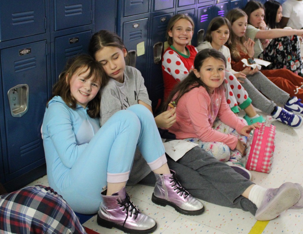 students pose in hallway with their cookies