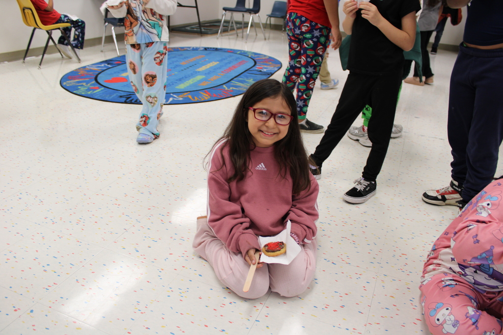 student poses with decorated cookie