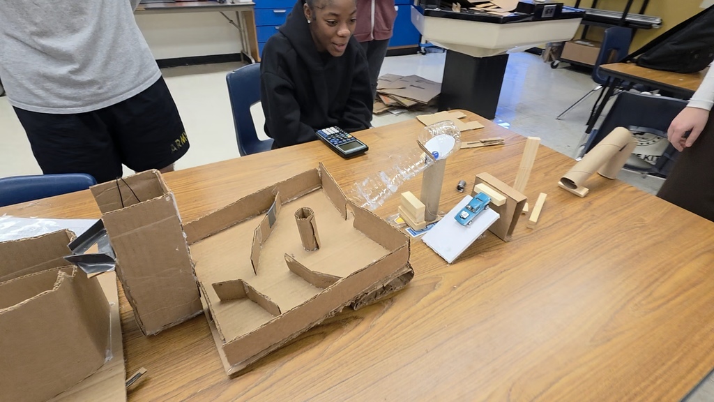 Physics students creating a Rube Goldberg machine