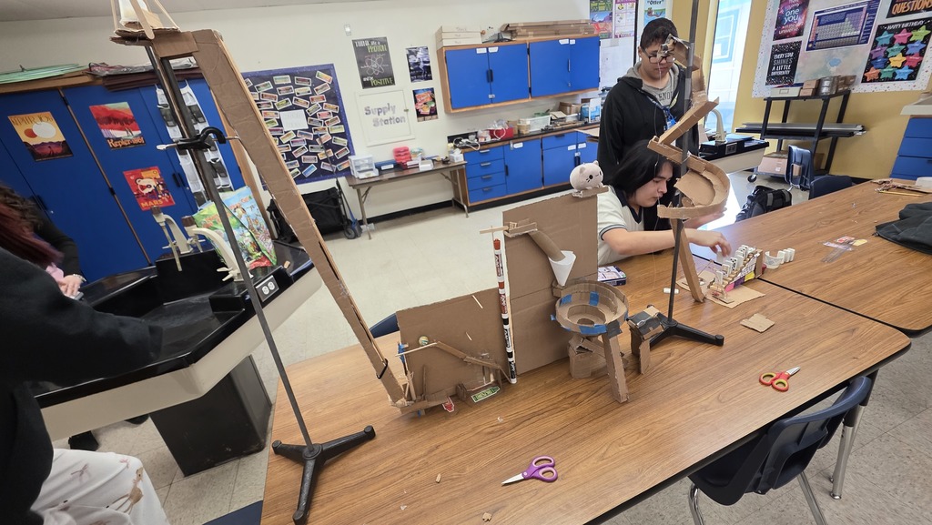 Physics students creating a Rube Goldberg machine