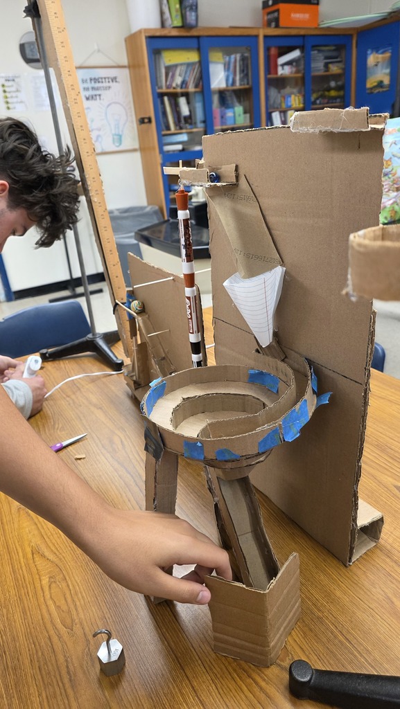 Physics students creating a Rube Goldberg machine