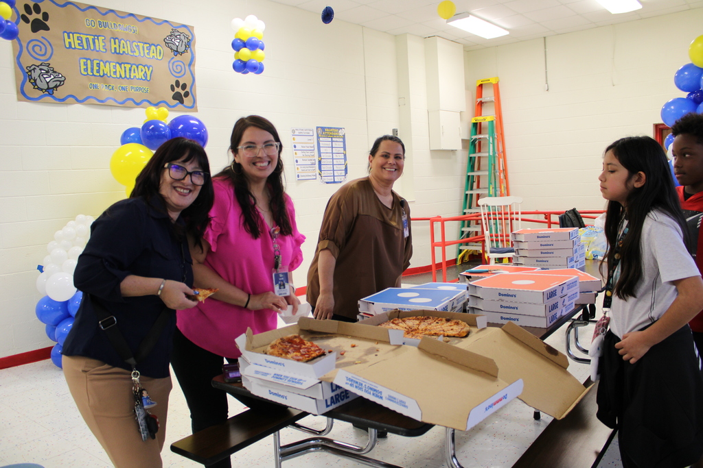 Staff pose while serving pizza
