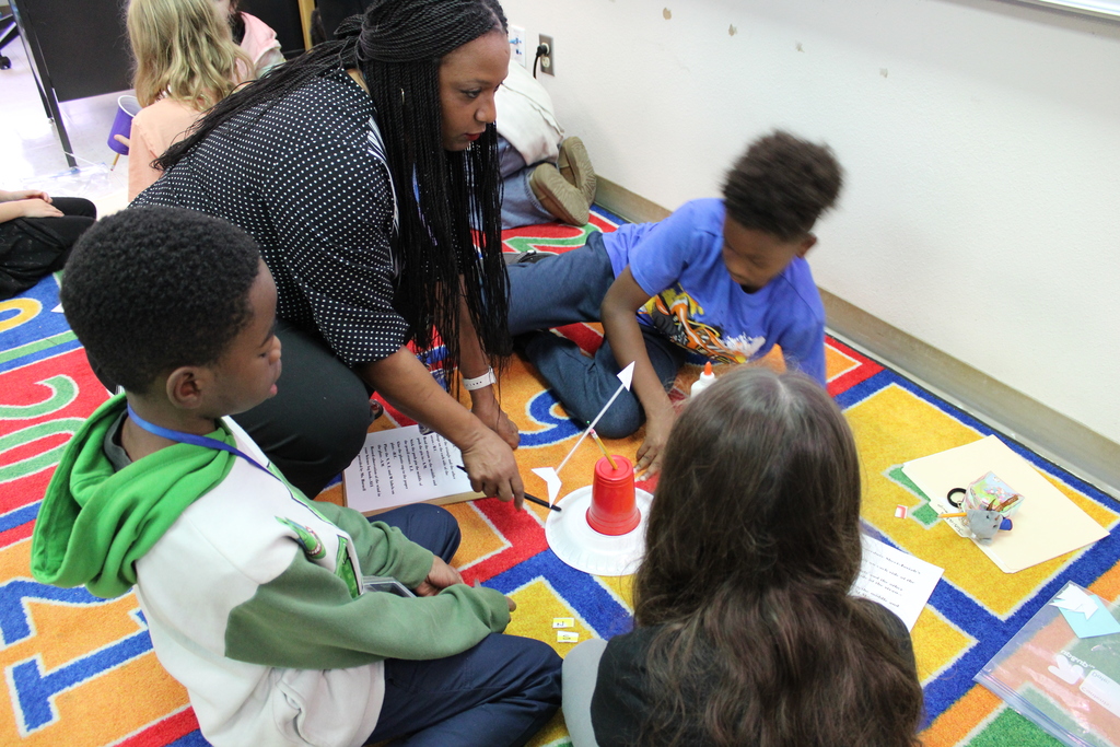 Ms. Burnell helps students with weather vane build