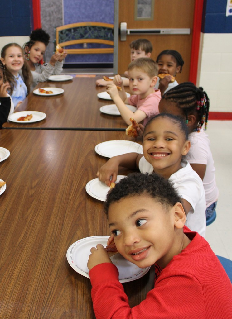 Students at table enjoying pizza