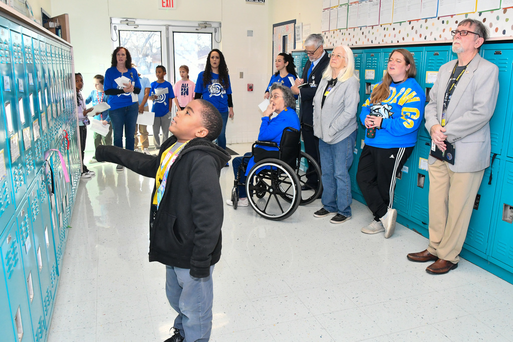 A group of students and board members talking in a hallway