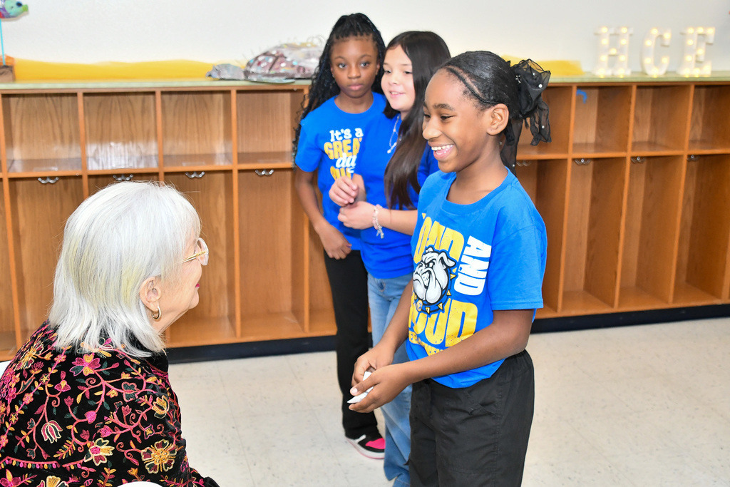 A student smiling, talking to a trustee