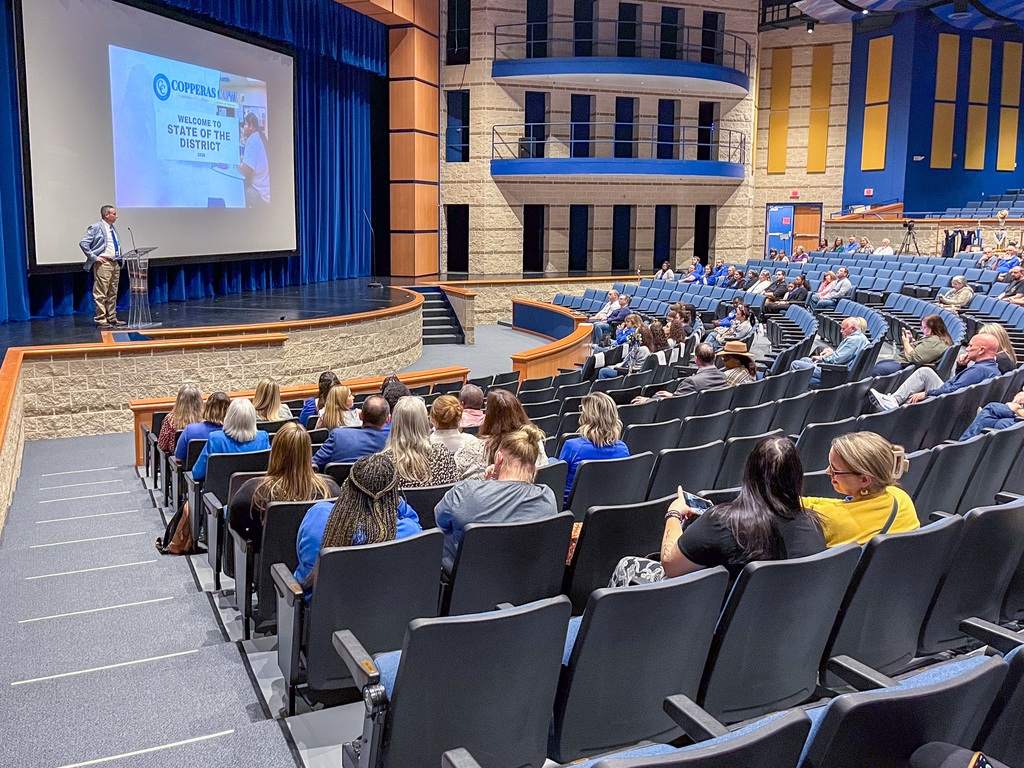 Photo of a man presenting to an audience in an auditorium