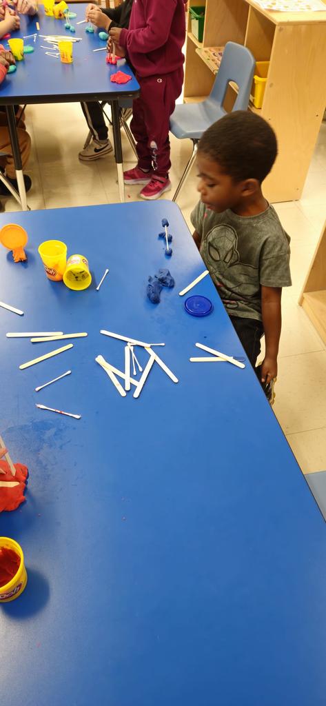 Students buidling a house out of sticks, q-tips and playdoh