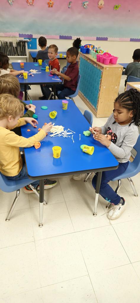 Students buidling a house out of sticks, q-tips and playdoh