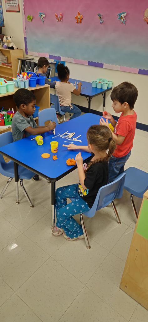 Students buidling a house out of sticks, q-tips and playdoh