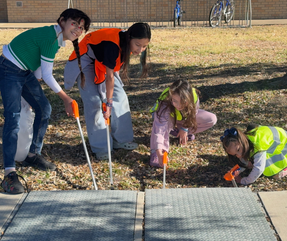 Students in safety vests cleaning our campus
