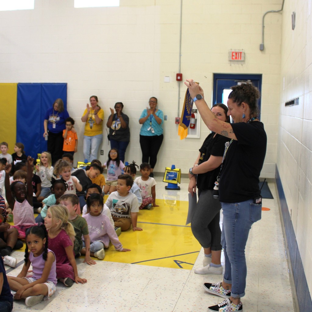 Winner of Top Bulldawg class holds banner up to excited students