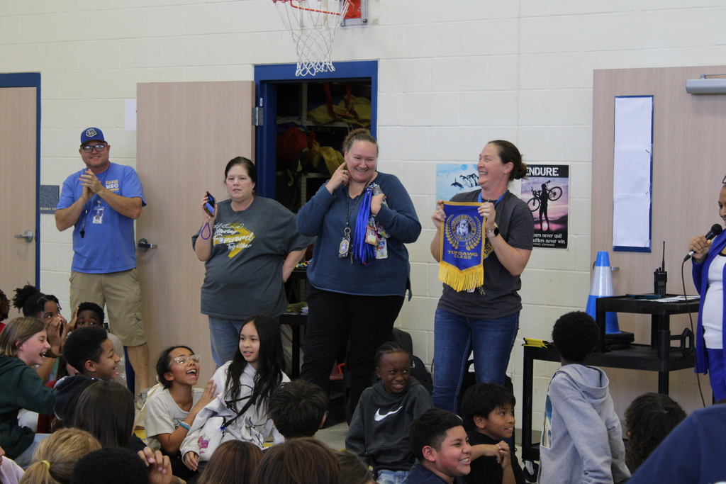 Winner of Top Bulldawg class holds banner up to excited students